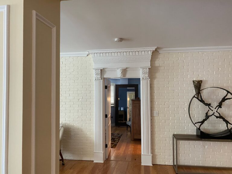 Shows a walking way in a home, the walls are painted nicely, one of them is painted brick.