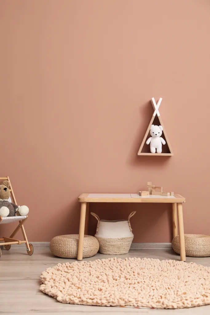 Cute child room interior with furniture, toys and wigwam shaped shelf on pink wall