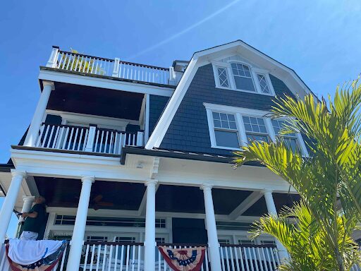 A large home, professionally painted in a deep blue and white paint.