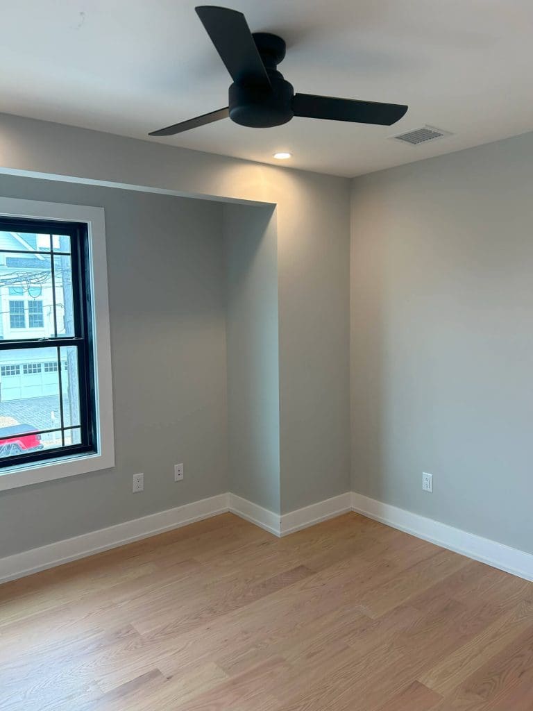 Newly painted living room in Beachwood, NJ with wood floors and modern ceiling fan.