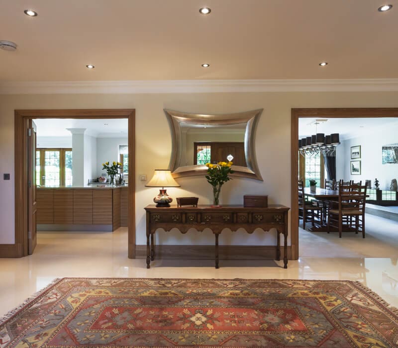 interior-painting-asbury-nj Elegant entryway of a modern home with a decorative mirror, console table, and Persian-style rug in Ocean County, NJ.