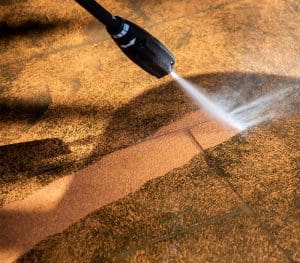 Carfagno team member power washing a dirty residential floor in ocean county nj
