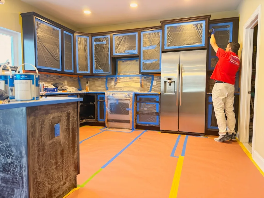 Carfagno painter refinishing masked kitchen cabinets.