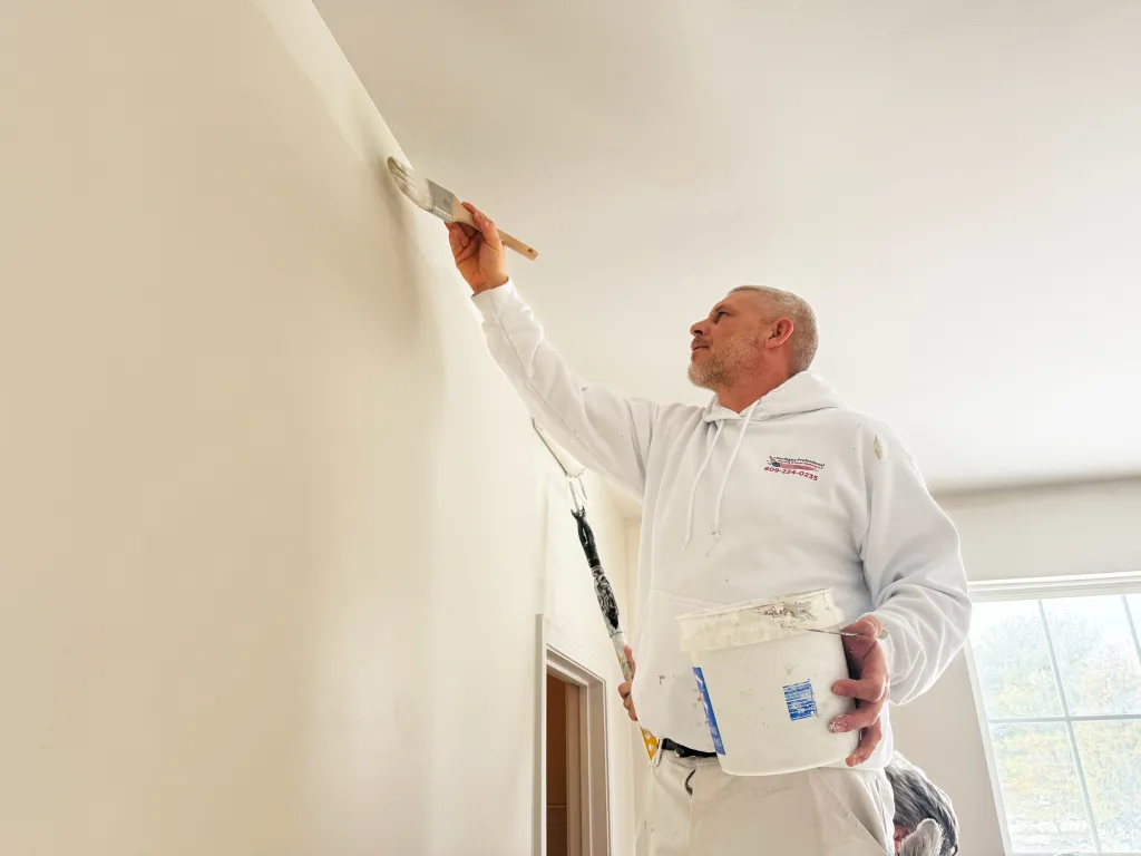 Carfagno painter cutting in a wall along the ceiling.
