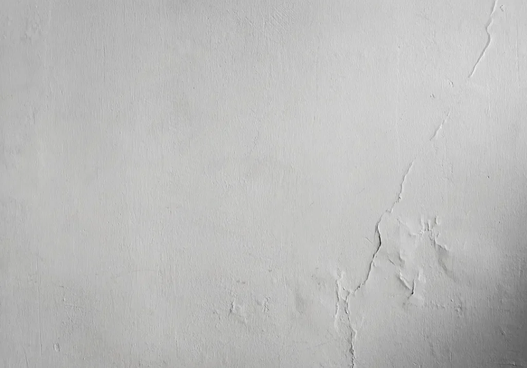 A white painted wall, with cracks forming across the right side.